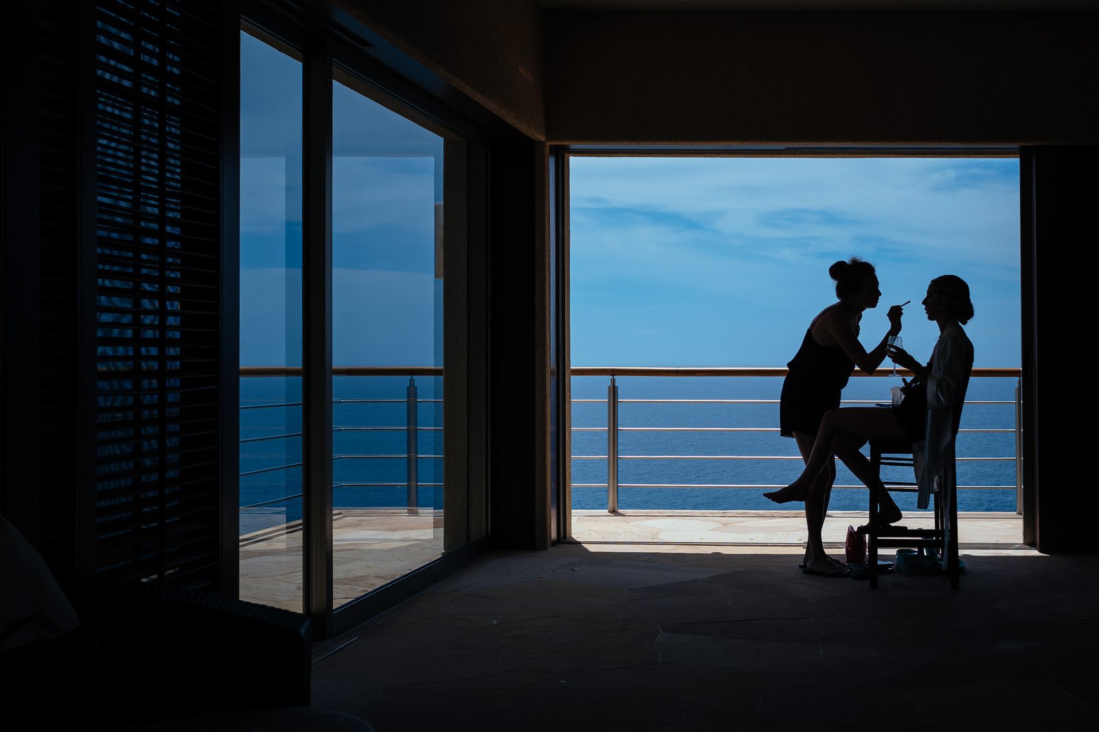 Bride getting ready in silhouette on a terrace over the sea — documentary wedding photography in Mexico by Dennis Berti